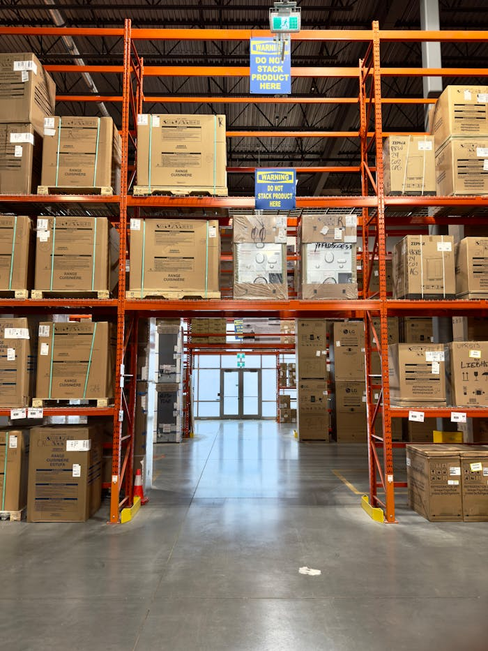 services-04 Large warehouse interior with racks filled with cardboard boxes, offering ample storage space.